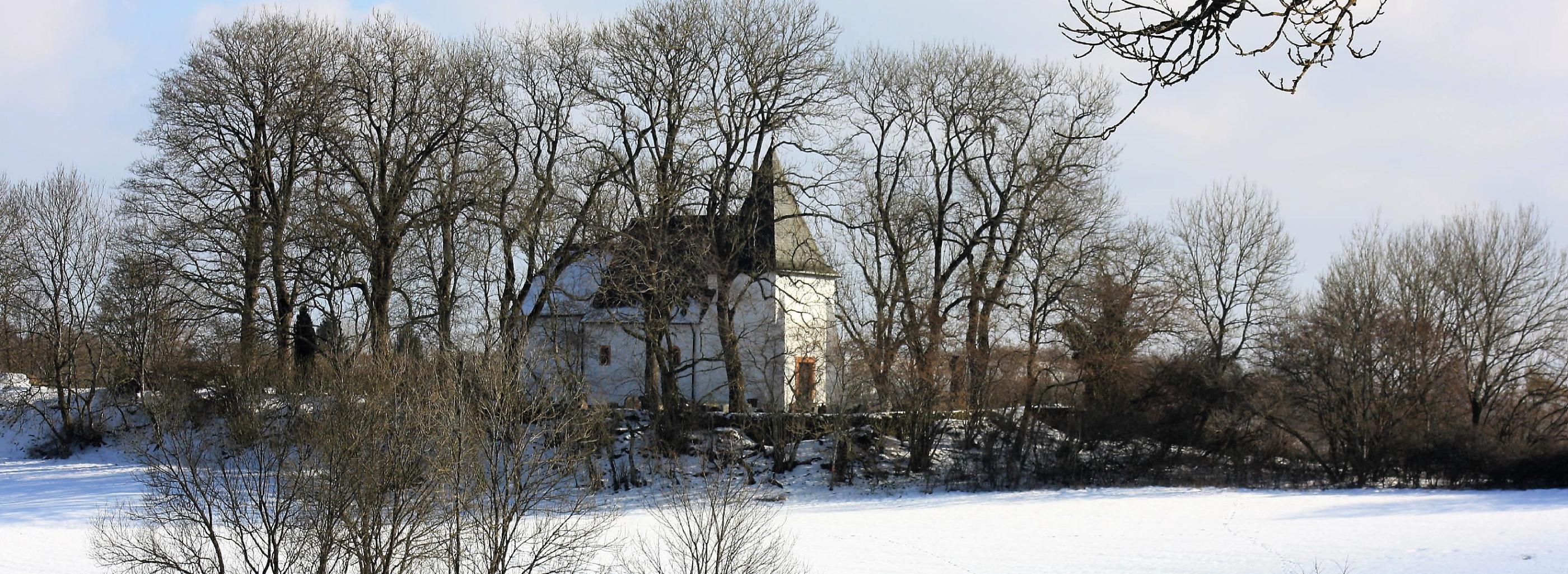 Zu sehen ist die Kirche am Weinfelder Maar im Winter.